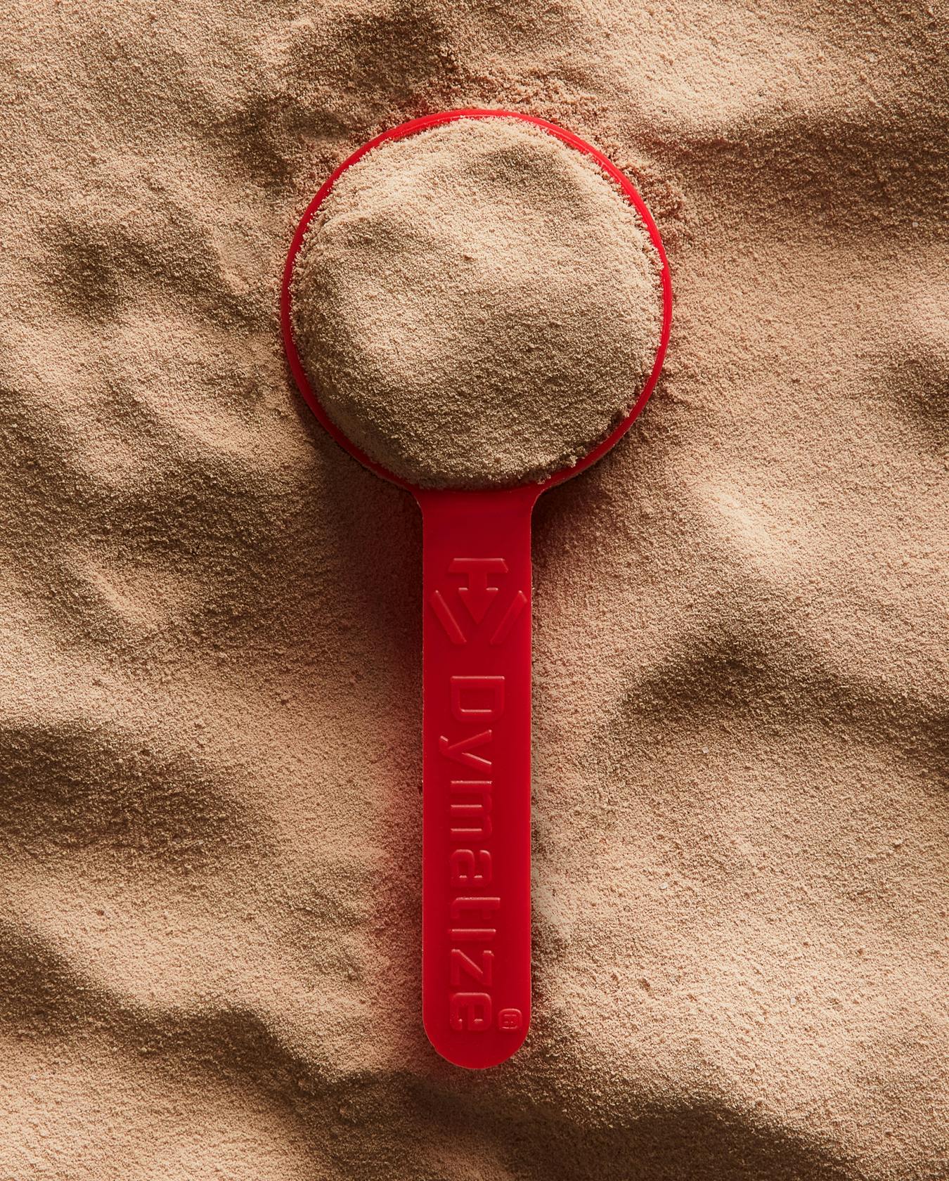 A scooper filled with Dymatize powder.